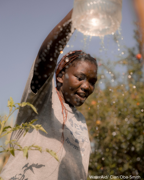 LIQUID I.V. IN PARTNERSHIP WITH WaterAid. Women walking with water bottle in hand